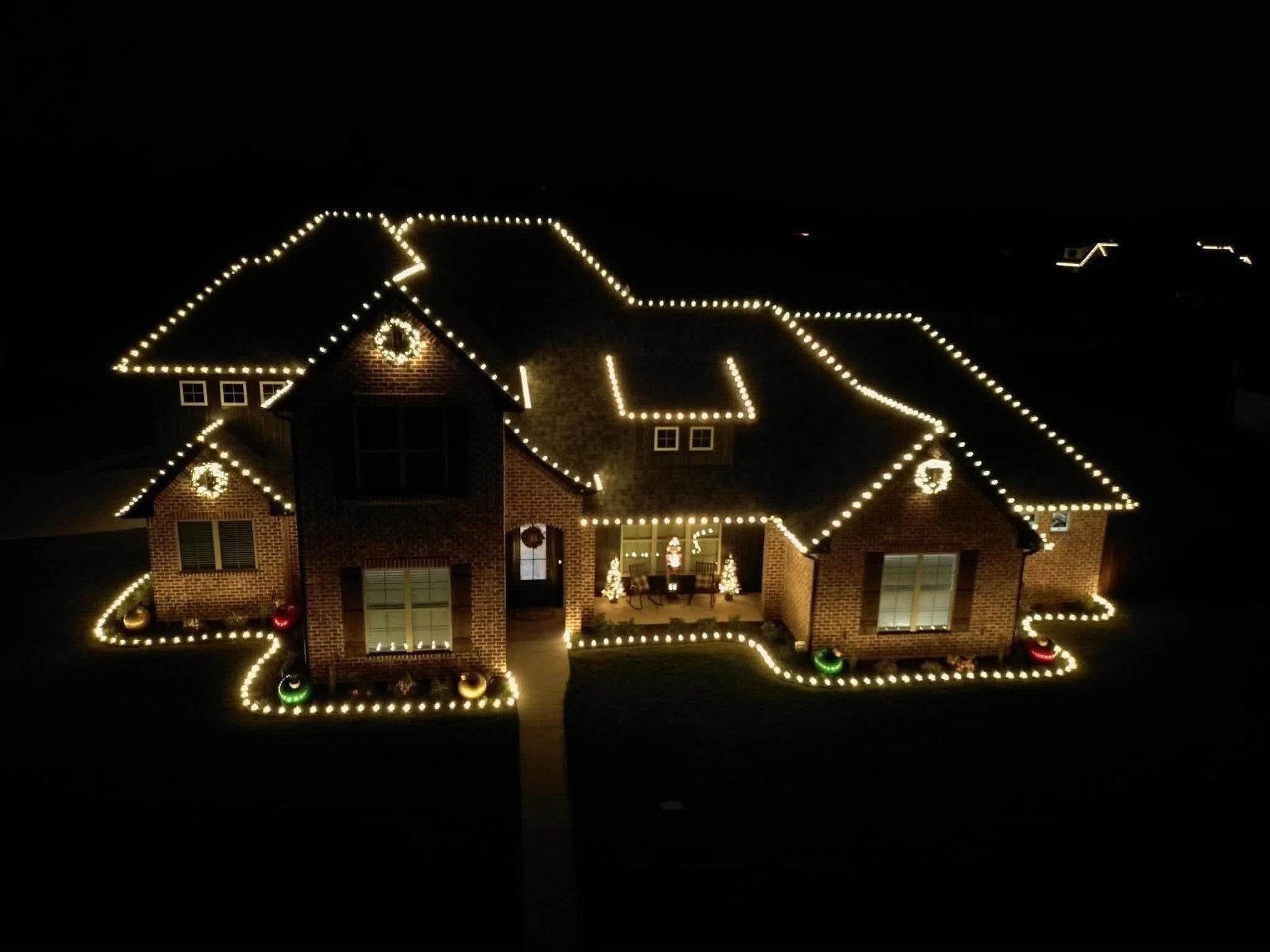 A Cincinnati-area home with its full roofline outlined in warm white Christmas lights at night, installed by Mike’s Cincinnati Christmas Lights